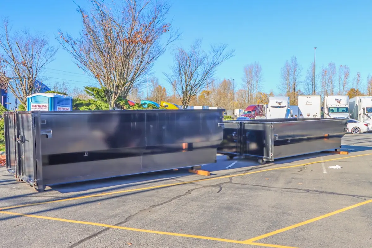 Professional dumpster rental service with roll-off container on residential driveway in Four Square Mile